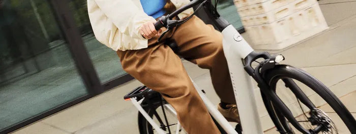Eine Person fährt ein modernes Gazelle Bike auf einem Gehweg, geeignet für Stadtpendler.