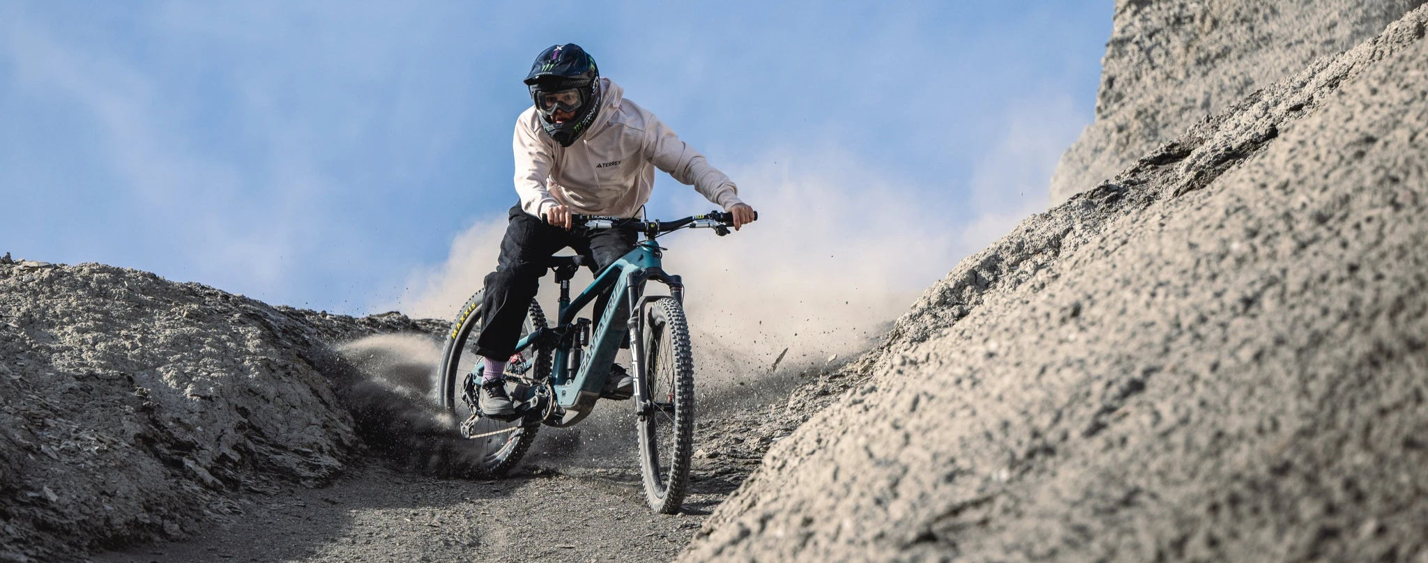 Person fährt Santa Cruz Bullit Mountainbike in staubiger Berglandschaft bergab.