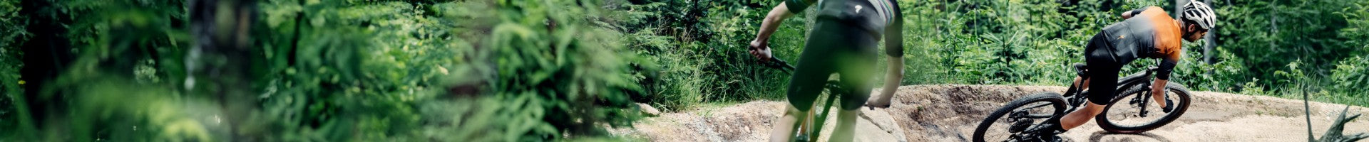 Zwei Mountainbiker fahren auf einem Waldweg; geeignet für Outdoor-Enthusiasten und Sportler.