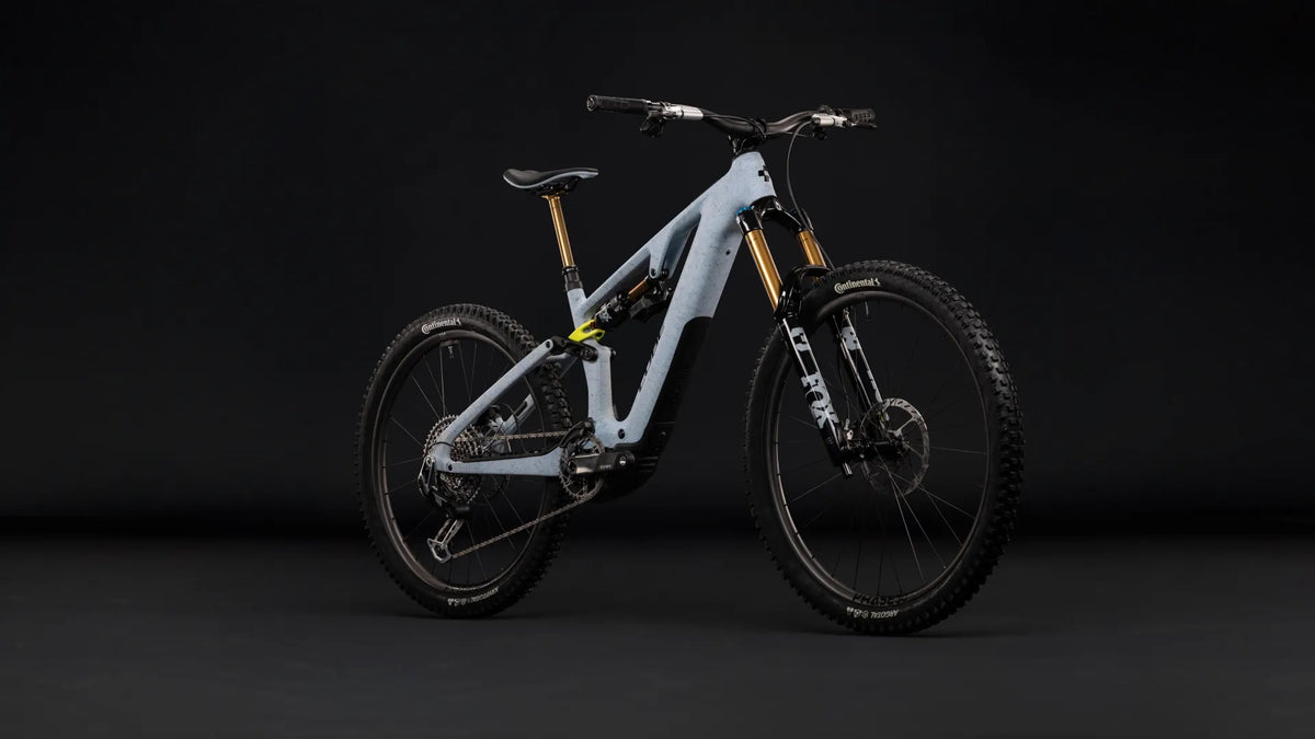 Hellgraues CUBE AMS HYBRID 177 C:62 SUPER TM 600X E-Bike mit robusten Fox-Federgabeln und Continental-Reifen auf dunklem Hintergrund.