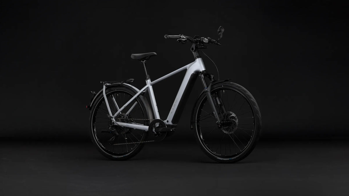 Weißes CUBE KATHMANDU HYBRID 45 800
, robustes Design für Stadtfahrten, mit Schutzblechen, Scheibenbremsen und integriertem Akku.