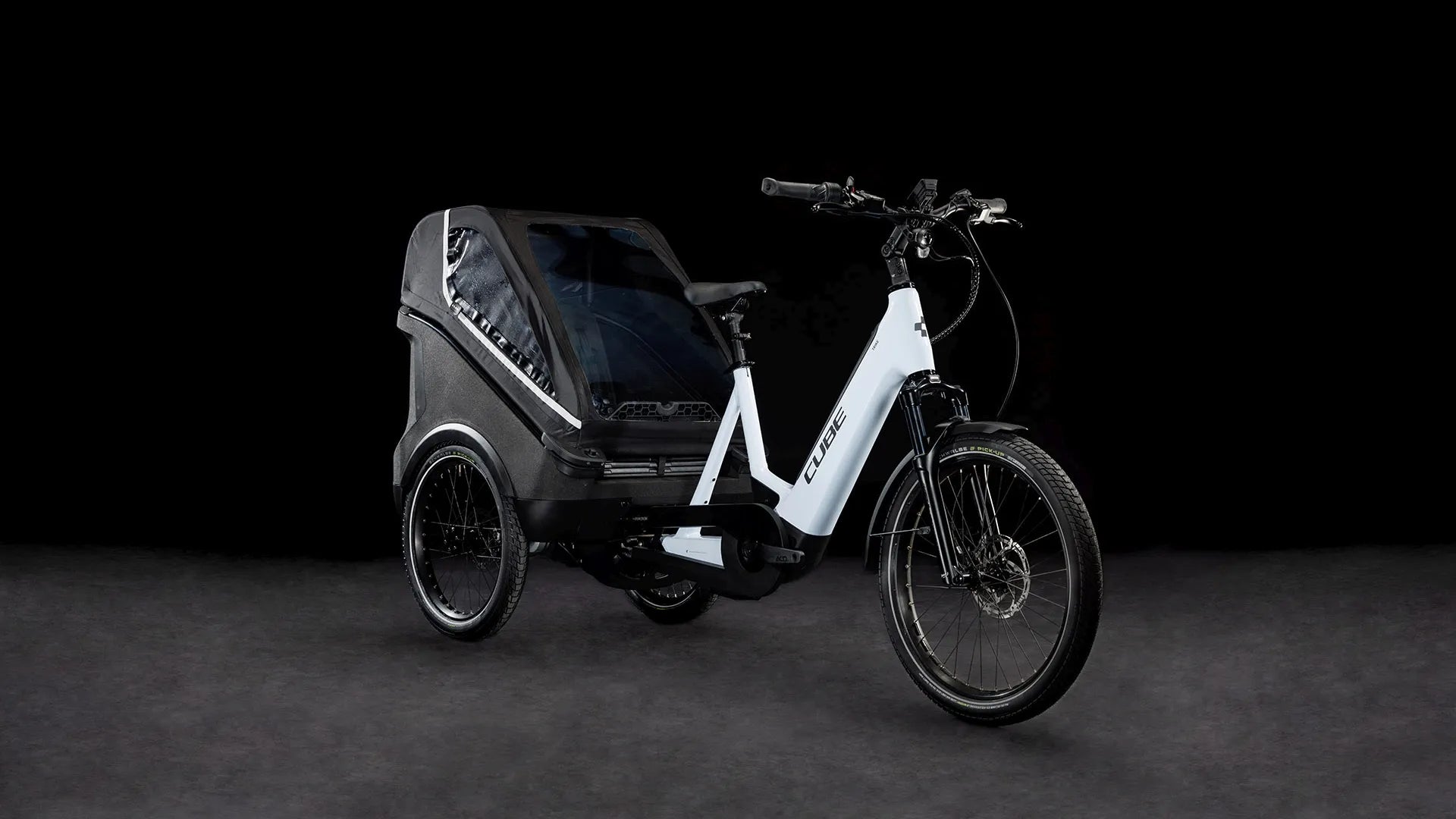 Lasten-E-Bike CUBE TRIKE FAMILY HYBRID 750 mit Anhänger für Transport oder Familienausflüge, weißes Design, geeignet für urbane Mobilität.